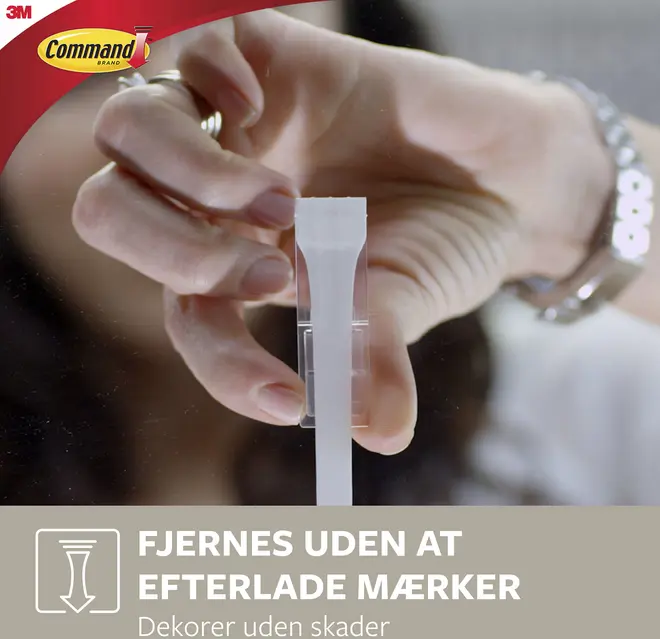 Klar Command klæbekrog fjernes fra en overflade med hånden. Designet til skånsom ophængning, efterlader ingen mærker. Ideel til dekoration uden vægskader.