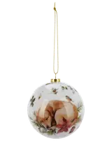 Rund julgranskula i glas med målad sovande hund, röda julstjärnor, grönska och små fåglar, guldfärgad topp och upphängningsband.