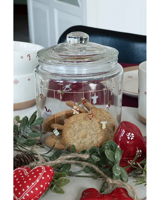 Klar glasbeholder med låg, dekoreret med festlige hængende ornamenter, fyldt med småkager. Ideel til opbevaring af snacks, lufttæt lukning og julemotiv. Perfekt til køkken eller gave.