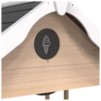 Detalje af legehus i træ med sort, rundt skilt med hvid isvaffel-illustration under hvidmalet gavl. Naturlig træfinish med vandrette paneler.