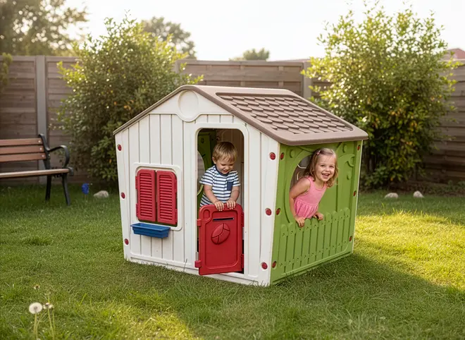 Plastik legehus til børn med brunt tag, hvide vægge, grøn side, rød dør, røde vinduesskodder og blå vindueskarm. Velegnet til udendørs leg i haven.