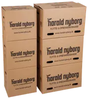 Stak af seks brune pap flytte- og opbevaringskasser med håndtag og Harald Nyborg-logo. Kasserne er rektangulære, solide og velegnede til opbevaring og flytning.