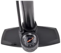 Close-up view of a sturdy black base with textured foot pads, a thick cylindrical tube, and an attached analog pressure gauge. The gauge features a clear dial with white markings, a red needle, and a black background, allowing precise pressure readings. A hose is connected to the side of the tube for air delivery.