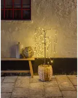 Dekorativ konstgjord träd med varmvita LED-ljusslingor i en flätad korg. Passar både inomhus och utomhus, ger mysig stämningsbelysning.