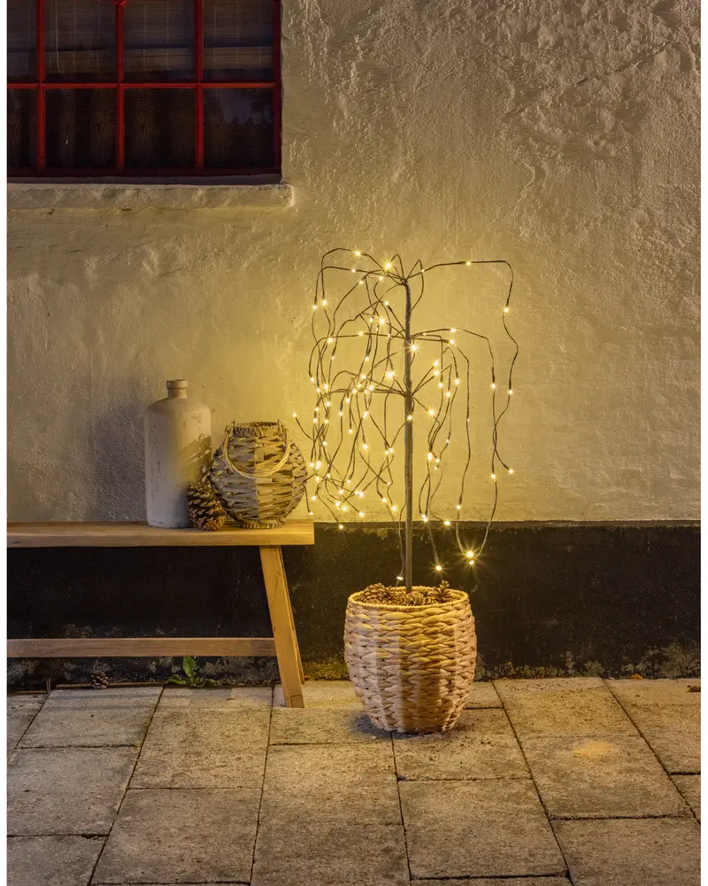 Dekorativ konstgjord träd med varmvita LED-ljusslingor i en flätad korg. Passar både inomhus och utomhus, ger mysig stämningsbelysning.