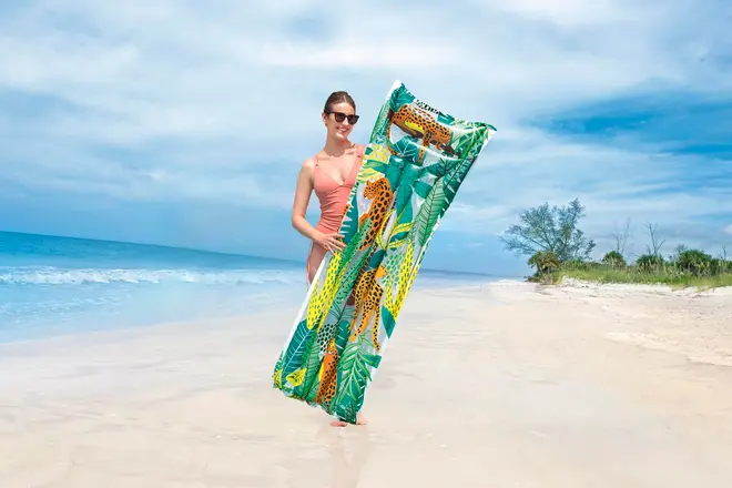 Uppblåsbar badmadrass med färgglatt djungelmönster, geparder och gröna blad. Rektangulär form med inbyggd kudde. Passar strand eller pool. Lätt att bära.