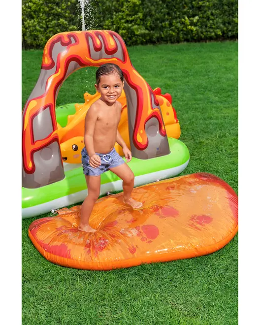 Oppusteligt vandlegcenter med vulkantema til børn, inkluderer rutsjebane, vandpude og bue med sprinkler. Farverig i orange, gul og grøn. Til udendørs brug.