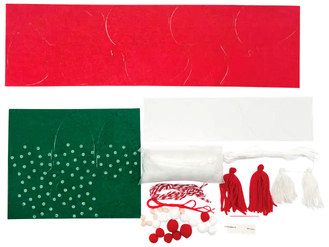 Julpysselkit med röda, gröna och vita filtark, pompoms, garn, stoppning och tofsar. Innehåller utskurna former och dekorationer för att skapa julprydnader.