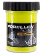 Klar beholder med sort låg, fyldt med gul ørreddej med hvidløgssmag. Etiketten viser en fisk, hvidløgstegning og teksten 'Forellenteig Knoblauch.'