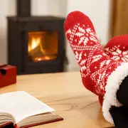 Röda och vita stickade toffelstrumpor med snöflingemönster och mjukt fleecefoder, perfekta för värme och komfort inomhus på vintern.