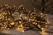 Varme hvide LED-gren lyskæde med sort ledning, designet til dekoration. Flere grene med små lysende pærer, ideel til festlig eller stemningsfuld belysning inde eller ude.