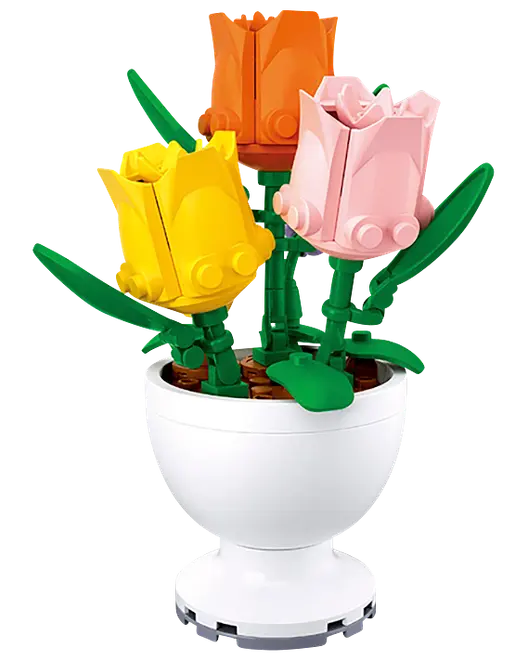 Tre LEGO-liknande tulpaner i gult, rosa och orange med gröna stjälkar och blad, arrangerade i en vit piedestalvas.