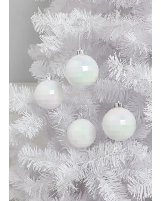 Sæt med fire iriserende hvide facetterede julekugler med sølvtoppe, hængende på et hvidt kunstigt juletræ. Moderne og elegant design til juleudsmykning.