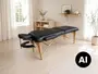Sort bærbar massageterapi-briks med polstret delt overflade, justerbar ansigtsstøtte, sidearmlæn og sammenklappelige træben i et lyst rum. - Billedet er skabt med AI