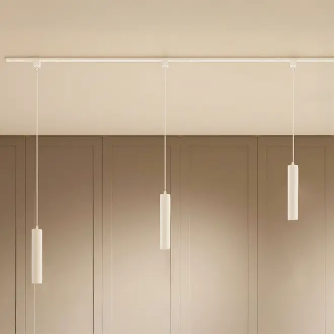 Minimalistisk pendellampe med tre slanke, cylindriske hvide vedhæng, der hænger fra en hvid loftsskinne. Perfekt til moderne indretning og giver fokuseret, elegant belysning.