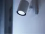 Moderne vægmonteret spotlampe med cylindrisk hvidt metalhus, udsender klart hvidt lys. Har en firkantet base til sikker montering, velegnet til accent- eller læsebelysning.