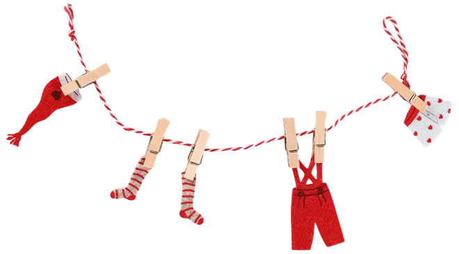 Rødt og hvidt babytøj hænger på en snor med tøjklemmer, inkluderer strømper, bukser, kjole og hat. Dekorativt, festligt design med hjerter og striber.