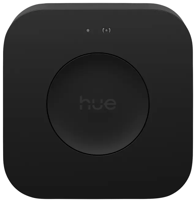 Sort, firkantet smart home-hub med afrundede hjørner, central cirkulær knap med 'hue', to små indikatorlys øverst. Minimalistisk design til styring af smart belysning.