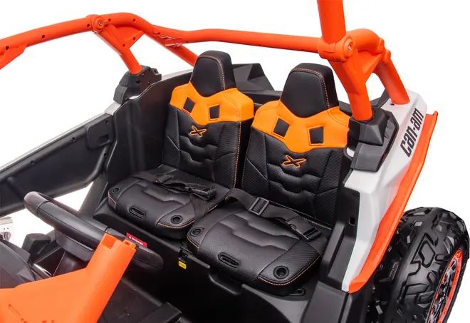To sorte og orange spandsæder med sikkerhedsseler i et legetøjs offroad-køretøj. Detaljeret syning, støbt plaststel og robust design. Rat og sikkerhedsbøjle ses.