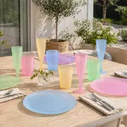 Sæt med pastelfarvede plastik tallerkener og glas i blå, pink, grøn og gul. Inkluderer drikkeglas og champagneglas, ideelt til udendørs spisning. Afslappet, moderne borddækning.