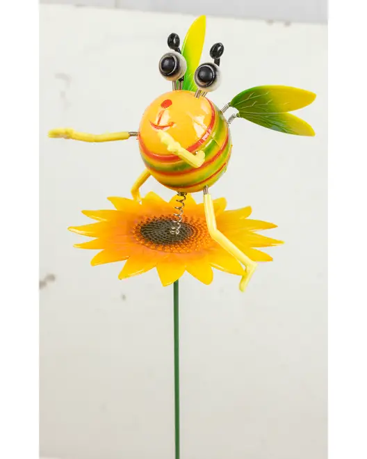 Färgglad trädgårdsdekoration i metall formad som ett bi med fjädrande armar och ben, stora ögon och gröna vingar, sittande på en gul solros.