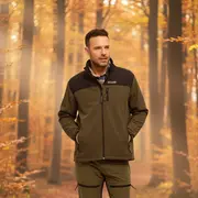 Herre outdoor sæt i olivengrøn med sorte detaljer, lynlåslommer og forstærkede knæ. Ideel til vandring, vist med brune støvler i skovmiljø.