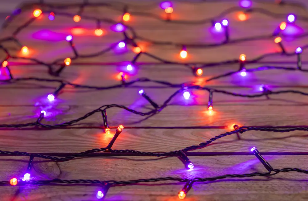 Ljusslinga med LED-lampor i orange och lila på svart sladd. Passar för inomhusdekoration, särskilt till Halloween eller festliga tillfällen. Lamporna är jämnt fördelade.