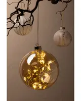 Stor klar julkula i glas fylld med varmvita LED-ljusslingor som ger ett glödande sken. Silverfärgad topp och upphängning ingår. Dekorativ, modern julprydnad för inomhusbruk.
