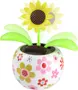 Plastik solsikke-legetøj med grønne blade i en rund, hvid potte dekoreret med farverige blomster. Har et lille solpanel på toppen til bevægelse. Lys og glad stil.