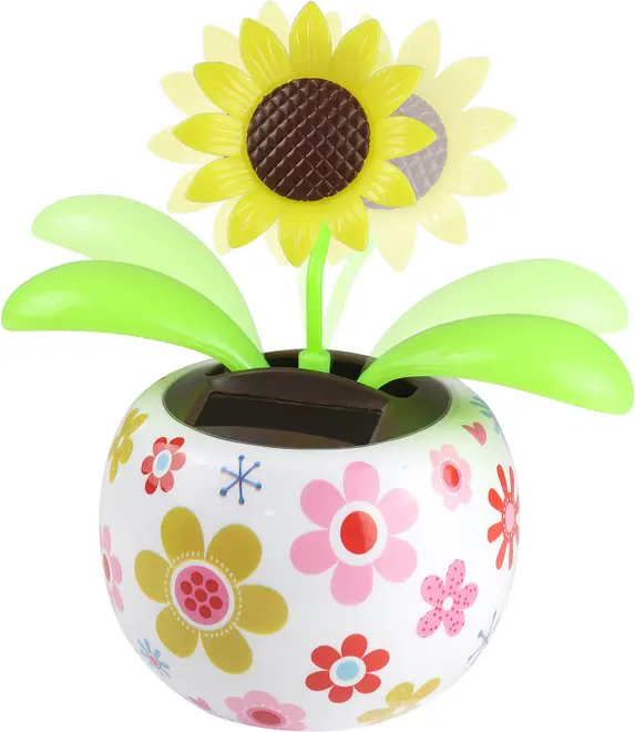 Plastik solsikke-legetøj med grønne blade i en rund, hvid potte dekoreret med farverige blomster. Har et lille solpanel på toppen til bevægelse. Lys og glad stil.