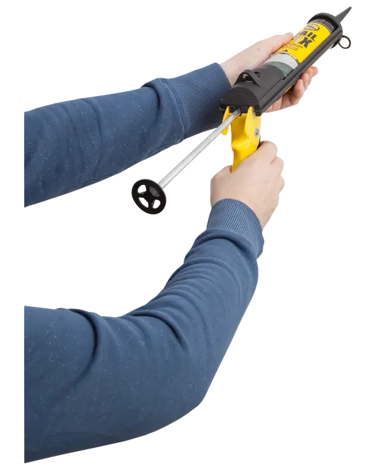 Hand håller en gul fogpistol med tätningsmassa, ergonomiskt handtag och avtryckare för exakt applicering av lim eller tätningsmedel vid bygg- eller reparationsarbeten.