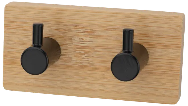Væghængt knagerække med to sorte metalknager på en rektangulær base af lyst træ. Moderne, minimalistisk design til ophæng af jakker, hatte eller tasker.