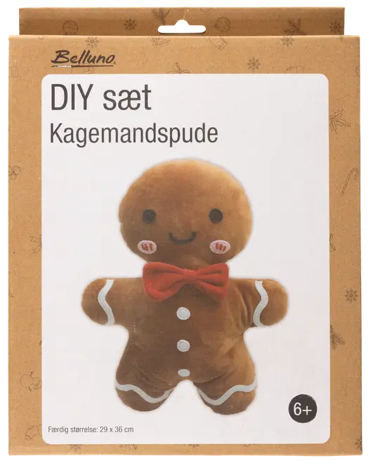 DIY-set för att göra en pepparkaksgubbe-kudde. Brun plysch, röd fluga, vita knappar, leende ansikte. Färdig storlek: 29 x 36 cm. Från 6 år.