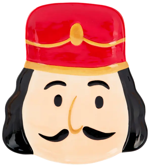 Keramiktallrik formad som en nötknäckares ansikte med röd hatt, svart hår, mustasch och enkla målade ansiktsdrag. Perfekt för festdukning.