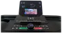 Løbebånds kontrolpanel med digitalt display, hastighedsregulering, hurtigknapper, start/stop, trådløs opladning, Bluetooth og en holder til smartphone. Moderne og brugervenligt design.