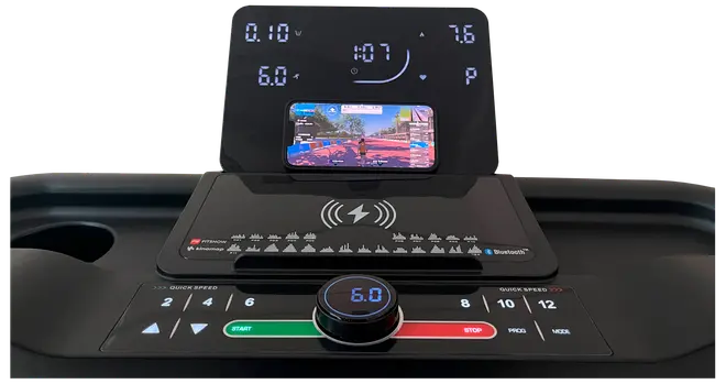 Løbebånds kontrolpanel med digitalt display, hastighedsregulering, hurtigknapper, start/stop, trådløs opladning, Bluetooth og en holder til smartphone. Moderne og brugervenligt design.