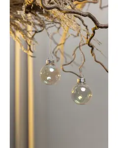 Set med två klara glasjulgranskulor med silverfästen, hängande i snören. Kulorna är runda, transparenta och har en subtil skimrande yta för festlig känsla.