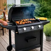 Sort gasgrill med tre drejeknapper, sidehylder og låg. Stor grillflade med mad på risten, sidebrænder og hjul for nem flytning. Moderne udendørs design.