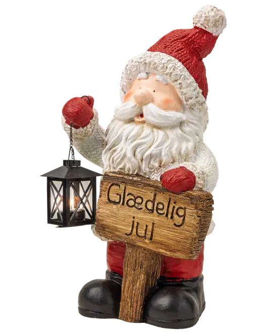 Julemandfigur med lanterne og træskilt med teksten 'Glædelig jul', rød hat, hvidt skæg og sorte støvler som festlig juledekoration.