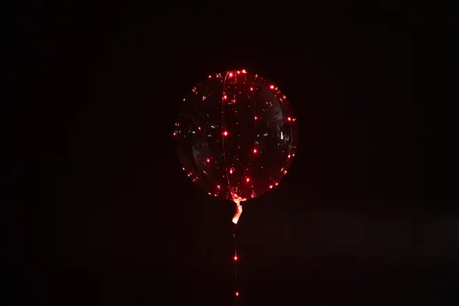 Gennemsigtig ballon med røde LED-lys indeni, som giver en glødende effekt. Rund ballon med snor, perfekt til fester eller dekoration.