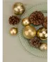 Set med gyllene julgranskulor i matt och glitter, tillsammans med naturliga bruna kottar på en texturerad glasplatta. Perfekt för festlig dekoration.
