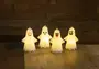 Fyra lysande LED-nattlampor formade som spöken med olika ansiktsuttryck, tillverkade av vit plast, perfekta för Halloween eller barnrum, placerade på en träyta.
