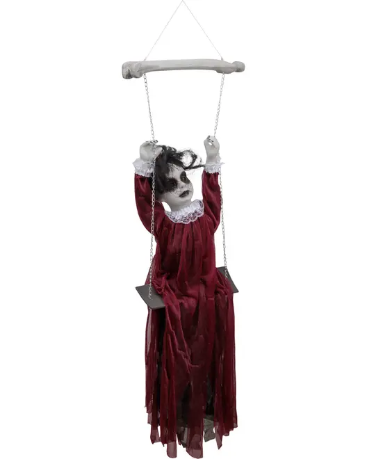Läskig docka som Halloween-dekoration med blekt ansikte, svarta ögon, rufsigt hår och trasig röd klänning, sittande på en gunga upphängd i kedjor från ett ben.