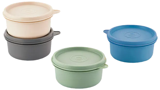 Sæt med fire runde plastikmadkasser med låg i beige, grå, grøn og blå. Hver beholder har en tap til nem åbning og en mat overflade.