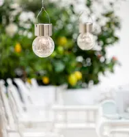 Hängande utomhus solcells-LED-lampa med krackelerad glaskula och rostfritt ståltopp. Utrustad med metallhandtag för enkel upphängning. Perfekt för trädgårds- eller uteplatsbelysning.