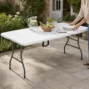 Foldbart bord dækket med service på en terrasse.