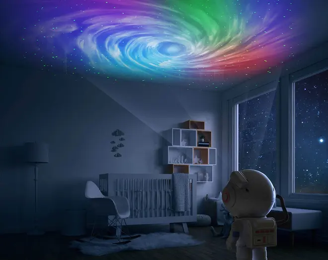 Natlampe i astronautform projicerer en farverig galakse og stjerner på loftet, perfekt til børneværelser eller vuggestuer, og skaber en beroligende og fantasifuld stemning.