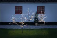 Set med tre konstgjorda utomhusträd med varmvita LED-lampor på grenarna, metallstavar för markplacering, passar trädgård eller uteplats, ger en festlig och upplyst effekt.