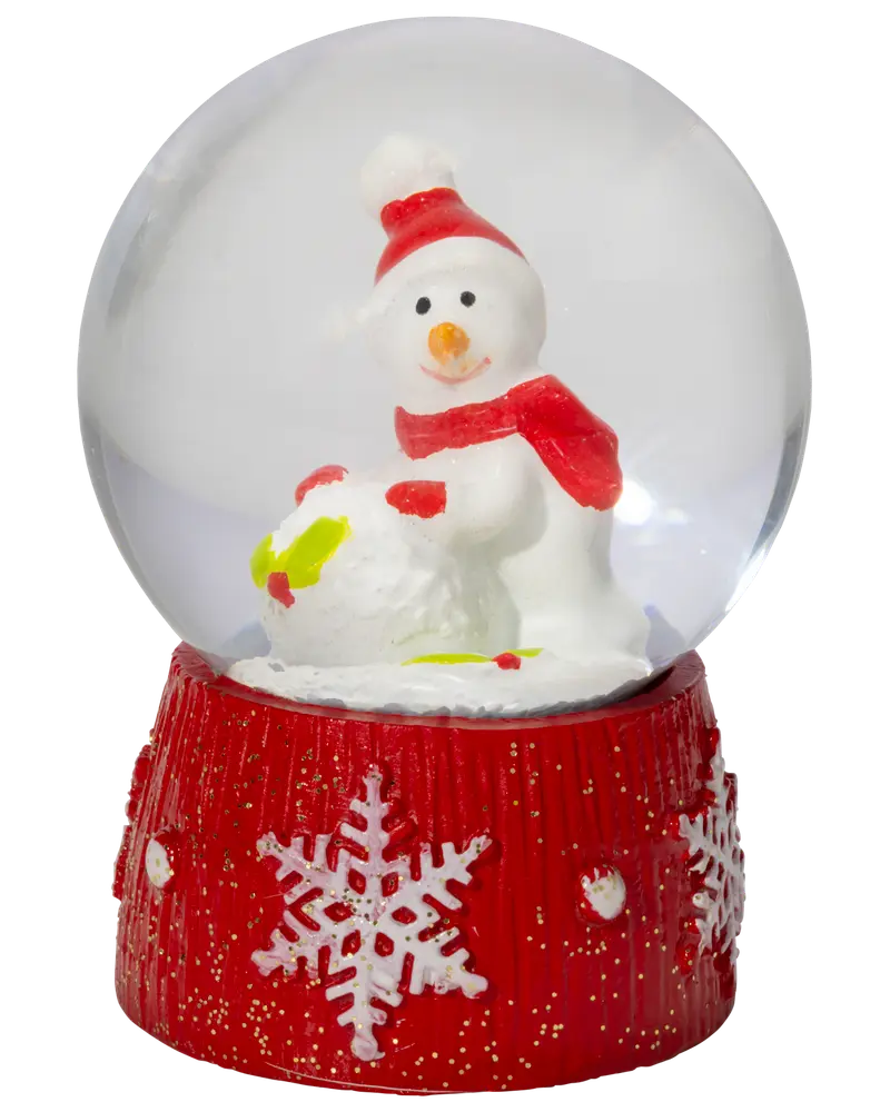 Glas-snöglob med snögubbe i röd mössa och halsduk, håller en snöboll. Röd bas med vita snöflingor och glitter. Festlig juldekoration.