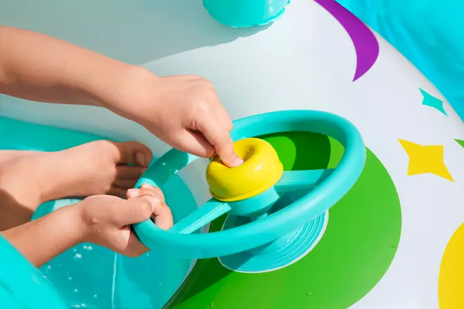 Oppustelig børnepool-flyder med turkis rat og gul horn, farverige stjerne- og cirkeldesigns, ideel til interaktiv vandleg og sikker poolsjov for børn.